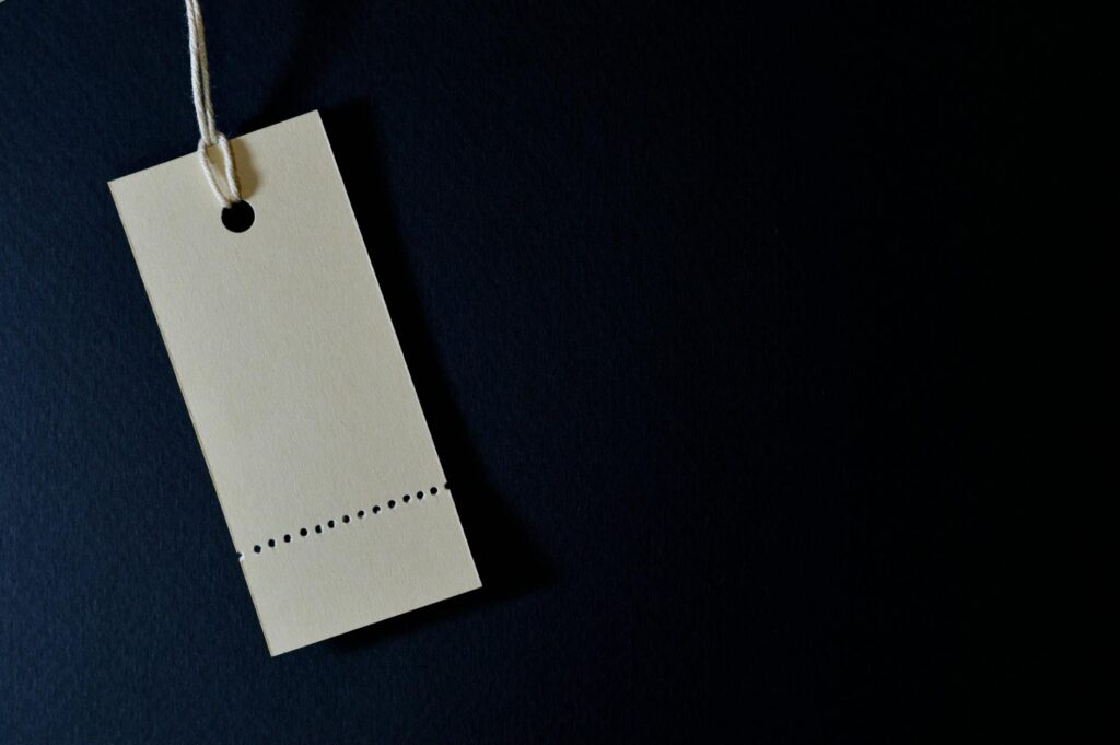 Elegant minimalist card with a string, ideal for labeling or pricing against a black background. (Photo by Miguel Á. Padriñán on Pexels)