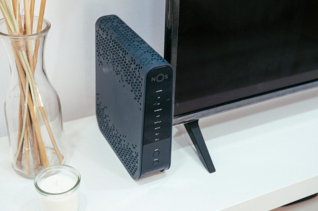 A sleek home technology setup featuring a router, glass decoration, and television. (Photo by Jaycee300s on Pexels)