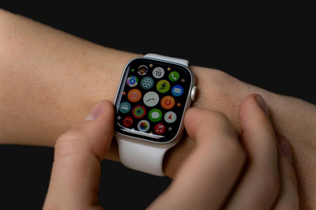 Close-up of person interacting with a smartwatch displaying apps on a dark background. (Photo by Anastasiya Badun on Pexels)