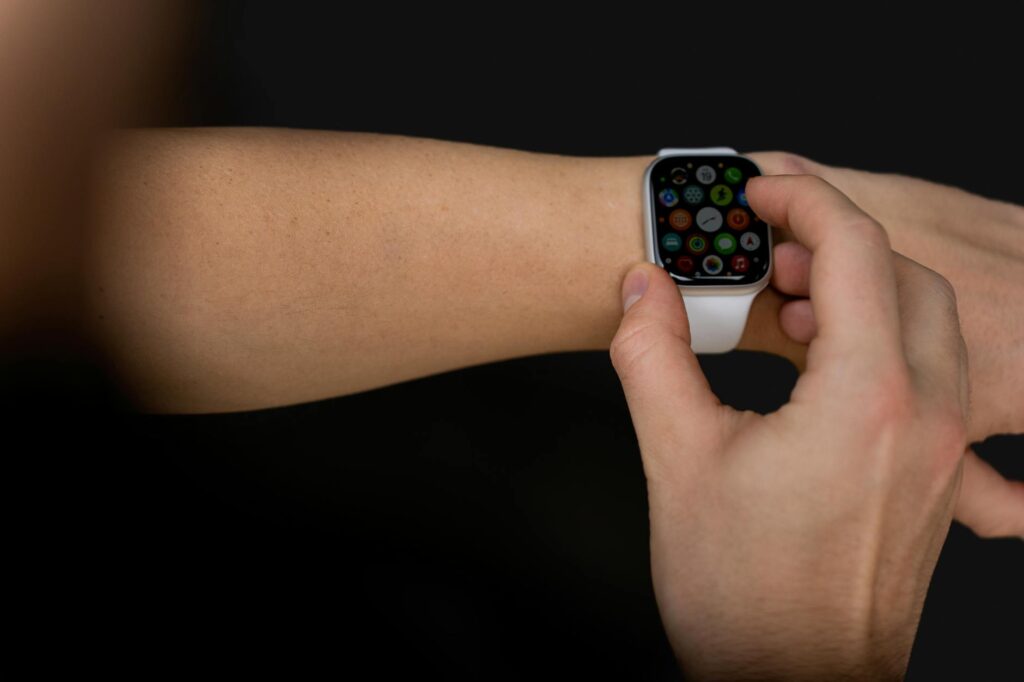 A person interacts with a touchscreen smartwatch against a black background, showcasing modern te... (Photo by Anastasiya Badun on Pexels)