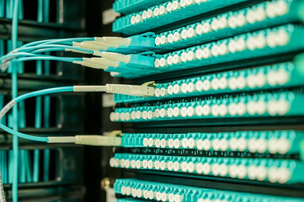 Networking cables plugged into a patch panel, showcasing data center connectivity. (Photo by Brett Sayles on Pexels)