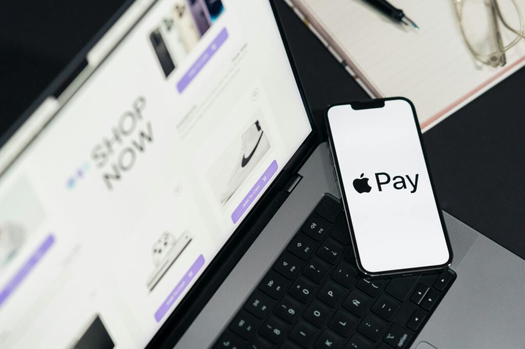 Laptop and smartphone display facilitating online shopping using mobile payment technology. (Photo by Julio Lopez on Pexels)