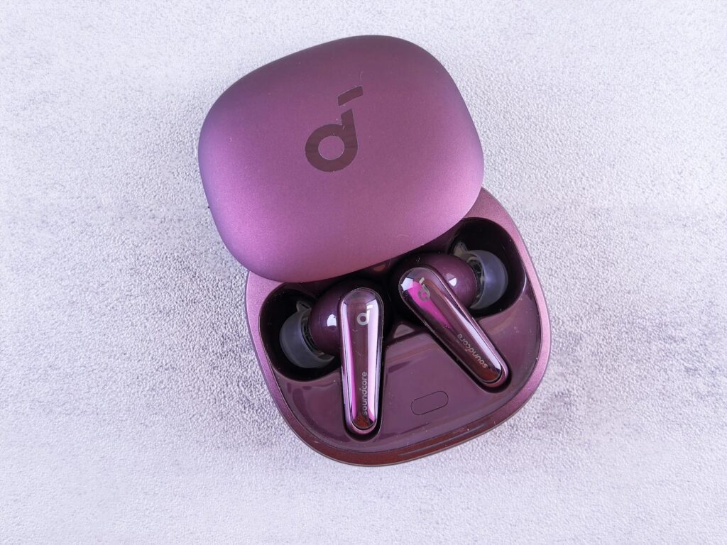 Modern purple earbuds resting in an open case, featuring glossy finish and sleek design. (Photo by Andrey Matveev on Pexels)