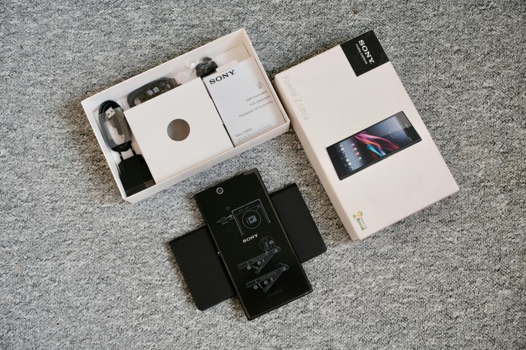 Detailed unboxing image of a mobile phone and its accessories, perfect for tech blogs. (Photo by Phong Thanh on Pexels)