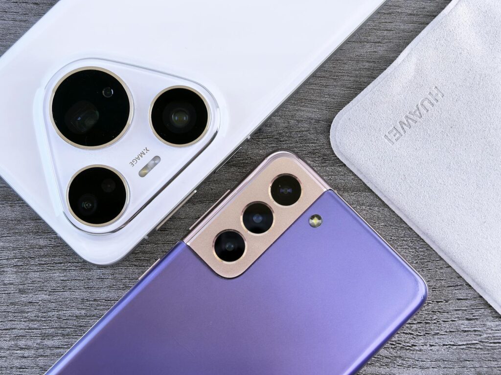 Close-up of two smartphones with camera focus on a textured wooden surface. (Photo by Andrey Matveev on Pexels)