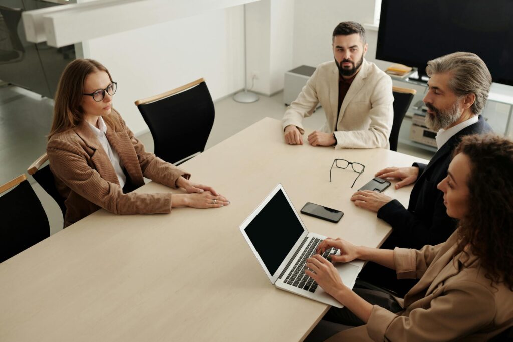Group of professionals having a business meeting in a modern office setting. (Photo by Edmond Dantès on Pexels)