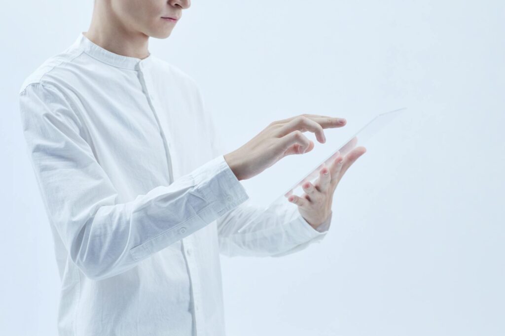 Person interacting with a transparent digital tablet, symbolizing technology and futurism. (Photo by Michelangelo Buonarroti on Pexels)